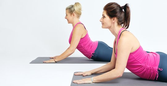zwei sportliche frauen pilatesuebung cobra