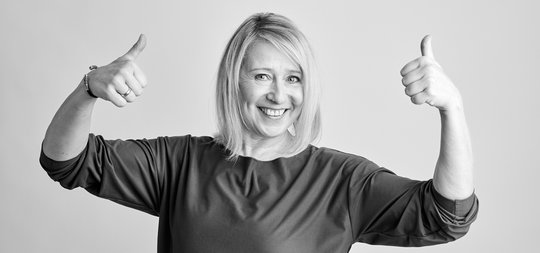 sportliche frau haelt daumen hoch als fitnessmotivation